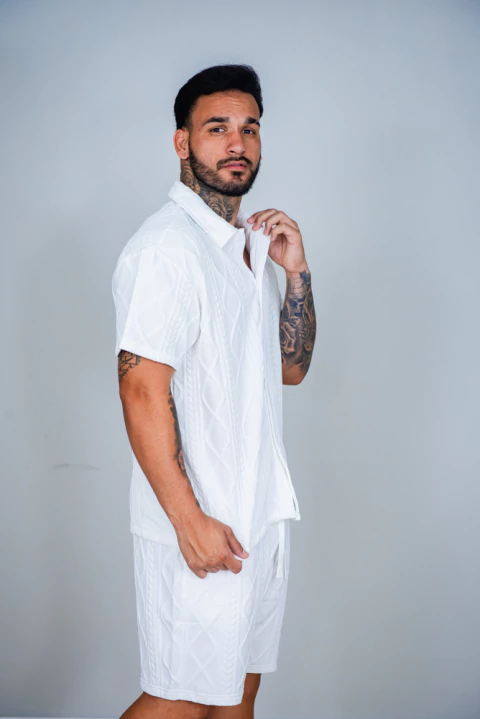 Homem vestindo conjunto 6D off white texturizado, composto por camisa de manga curta e bermuda, da Coleção Nova.