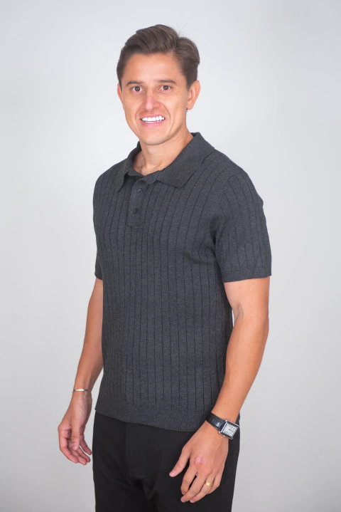 Homem vestindo camisa polo texturizada Line preta mescla de manga curta, com detalhes em relevo vertical, ideal para looks masculinos modernos.