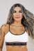 Mulher usando Top Marfim com detalhes em preto e marca UTAN visível.