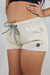 Short feminino infantil bege com cordão ajustável e detalhe de logo.