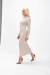 Modelo usando um vestido midi de ombro vazados na cor bege, com salto alto estampado de oncinha, posando em um fundo branco.