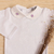 Body Bebê Suedine Gola Rococó Joyce - Branco com Lilás