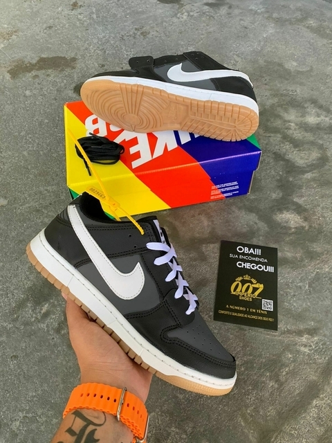 Desenvolvido com material em couro sua coloração predominante é preto com detalhes cinza as linhas de costura brancas o modelo acompanha com cadarços da cor branca.