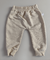 Calça moletom infantil essencial na cor areia, com elástico na cintura e punhos.