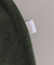 Calça infantil moletom essencial na cor musgo, mostrando a etiqueta da marca.
