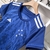Camisa feminina do Cruzeiro, modelo 24/25, na cor azul, com detalhes em estrelas e listras brancas.