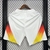 Shorts de futebol branco da Alemanha para a temporada 24/25, com detalhes em degradê nas laterais em cores laranja e amarelo.