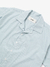Camisa boxy listrada verde com colarinho e etiqueta KMZ visível.