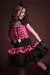 Menina sorrindo vestida com fantasia de caveira punk, usando blusa rosa com estampa de esqueleto e saia preta com babados.