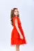 Menina usando um vestido de festa vermelho de tule, com detalhes em algodão, posando de lado.