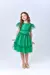Menina sorrindo vestindo um vestido de festa verde com tule, posando de forma alegre.