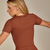 Camiseta Nanda feminina disponível em vermelho cereja, marrom, cinza e preto, feita com tecido suplex de alta qualidade para conforto e estilo durante treinos e atividades casuais.