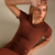Camiseta Nanda feminina disponível em vermelho cereja, marrom, cinza e preto, feita com tecido suplex de alta qualidade para conforto e estilo durante treinos e atividades casuais.