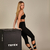 Top Rafa feminino de treino com alças finas e recorte cruzado, ideal para exercícios intensos. Disponível nas cores preto e marrom.