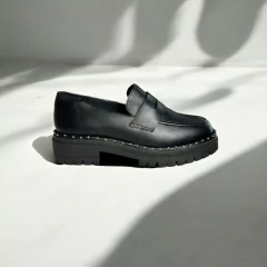 mocassim feminino minimalista preto com aplicações ao redor e plataforma tratorada
