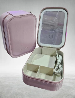 Organizador rosa con espejo y luz LED, abierto, mostrando compartimentos internos y un cable.