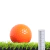Bola de golfe laranja sobre grama sintética azul de 20mm com régua para escala