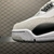 Side view of Air Jordan 4 "Fear" sneakers in white and black with suede and leather details.