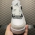 Front view of the Air Jordan 4 "Fear" sneakers in white and black, showcasing the laces and mesh details.