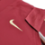 Detalhe da camisa retrô do Arsenal 2005/2006 na cor vinho, mostrando o logo da Nike em dourado.