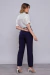 Mulher vestindo blusa de viscose com babados na cor off white vista de costas.