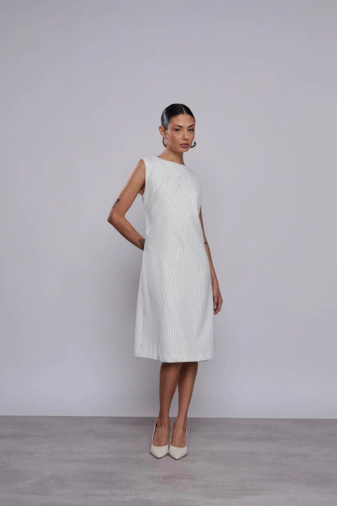 Mulher vestindo Vestido Midi Risca De Giz Off White, ideal para o inverno.