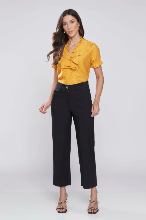 Modelo vestindo calça pescador alfaiataria Chloé preta com blusa amarela.