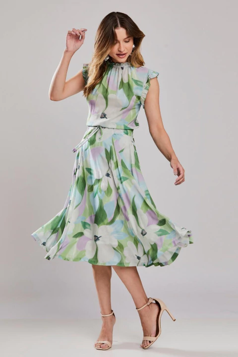 Mulher vestindo saia midi godê floral Cascais, com estampa de flores em tons suaves, ideal para o verão e ocasiões casuais.