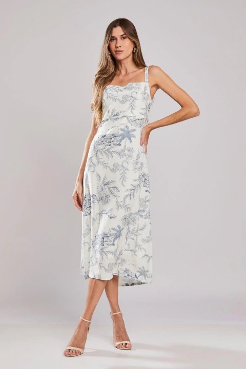 Mulher vestindo vestido longo Porto Unica com estampa floral azul e branca, ideal para o verão, em fundo neutro.
