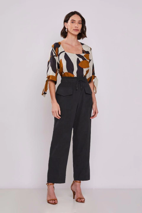 Modelo usando Calça Pescador Cupro Touch Preta, com blusa estampada e sandálias de salto alto.