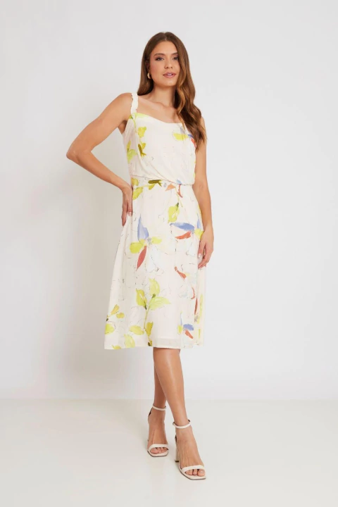Mulher vestindo um vestido midi floral de alças, com estampa delicada em tons claros e detalhes coloridos, ideal para o verão.