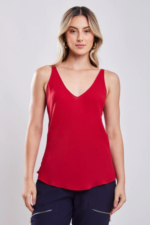 Mulher vestindo blusa básica vermelha de gola V, sem mangas, ideal para o inverno e looks casuais femininos.