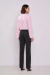 Mulher vestindo blusa rosa claro com gola chinesa vista de costas.