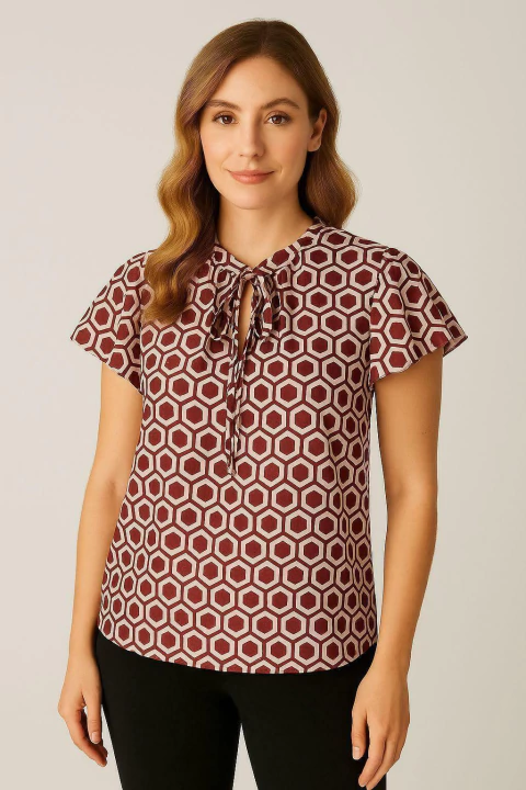 Mulher vestindo blusa feminina com estampa geométrica em tons de vinho e branco, com laço no decote e mangas curtas, pertencente à categoria outlet.