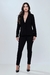 Mulher usando calça básica preta e blazer, ideal para looks de escritório.