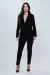 Mulher usando calça básica preta e blazer, ideal para looks de escritório.