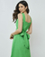 Mulher vestindo vestido midi verde com decote quadrado e laço nas costas.
