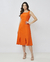 Mulher vestindo um vestido midi laranja com decote quadrado.