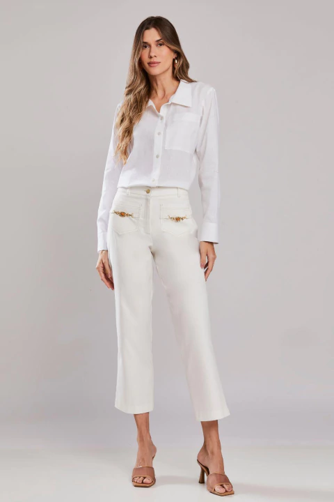 Mulher vestindo calça reta cropped Aveiro off white e camisa branca, em um look elegante de alfaiataria feminina para verão.