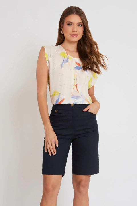 Mulher vestindo blusa regata floral clara e bermuda preta, ideal para o verão e looks casuais femininos.