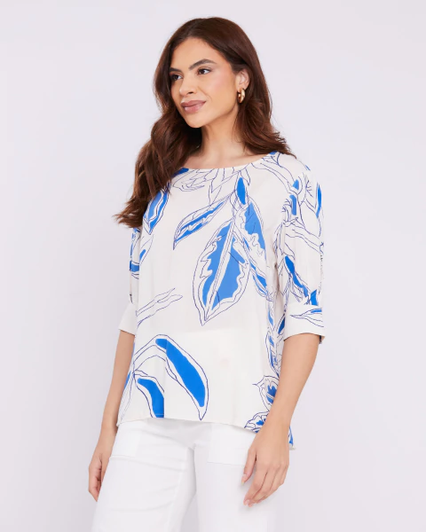Mulher vestindo blusa com detalhe transpassado e estampa azul