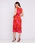 Mulher vestindo um vestido midi com estampa floral em tons de rosa e vermelho, vista de costas.