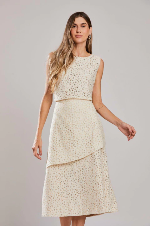 Mulher vestindo saia midi de renda na cor aveia, modelo Evora, ideal para o verão.