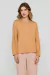 Modelo vestindo blusa Rubinella com mangas bufantes e decote redondo, na cor bege.