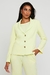 Mulher usando o Blazer Acinturado Verona Verde Claro Rubinella, com modelagem acinturada e botões frontais.