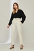 Mulher usando blusa feminina preta Versalhes com calça clara.