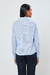 Camisa alfaiataria tricoline manga longa azul vista de costas em modelo feminina.