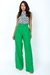Mulher vestindo calça pantalona de alfaiataria verde.