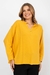 Mulher sorrindo com Blusa Crepe Viscose Amarela Rubinella combinada com calça preta.