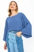 Modelo vestindo calça jeans mix com blusa azul de mangas largas